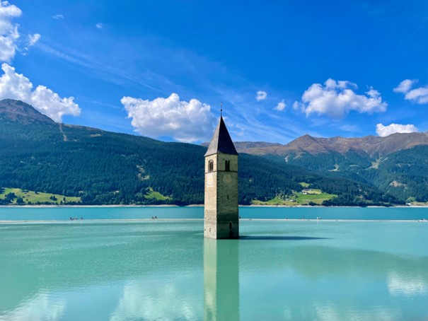 Abbildung 1: Der Reschensee ist das Wahrzeichen der Region Vinschgau - mit dem herausschauenden Turm können alle Hobbyfotografen auch noch auf ein schönes Motiv blicken. Bildquelle: @ Tommy Krombacher / Unsplash.com